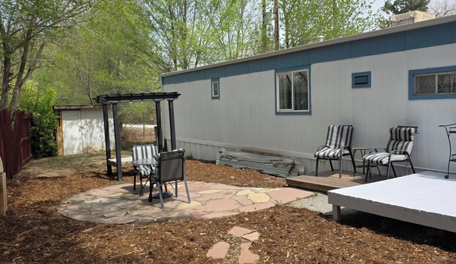 Spacious mobile home with large kitchen/living area and porch with barbeque.